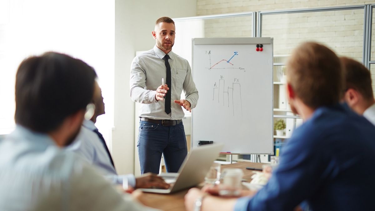 Professional delivering a presentation skills training session to a small group in an office setting