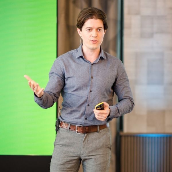 Ed Darling on stage gesturing while delivering public speaking training to a professional audience