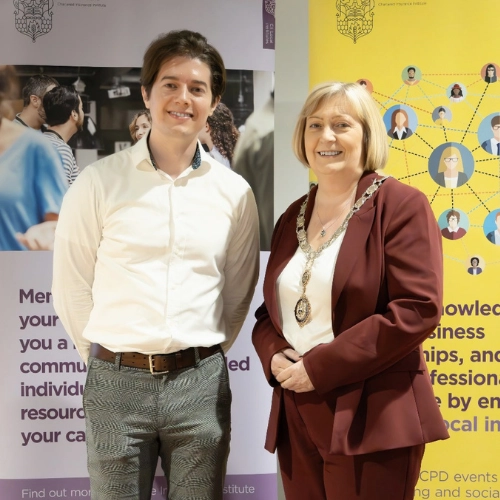 Ed Darling standing with the CII Belfast President on stage after delivering a keynote talk at the Northern Ireland Chartered Insurers Institute conference