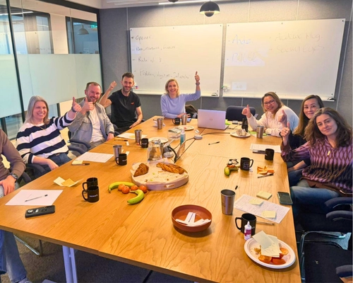 Group of professionals smiling and waving during an in-person public speaking workshop in Manchester as part of Project Charisma’s 1-to-1 coaching programme