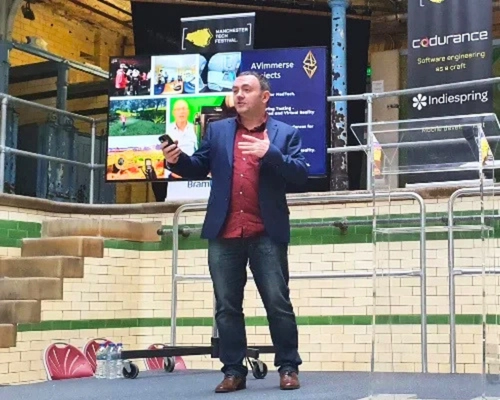 Male client delivering a confident speech on stage at a tech conference after completing Project Charisma’s 1-to-1 public speaking coaching programme