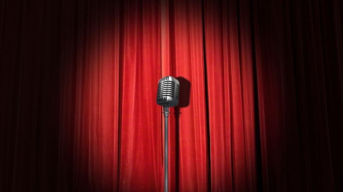 Microphone on an empty stage, waiting for a speaker to deliver an impromptu speech