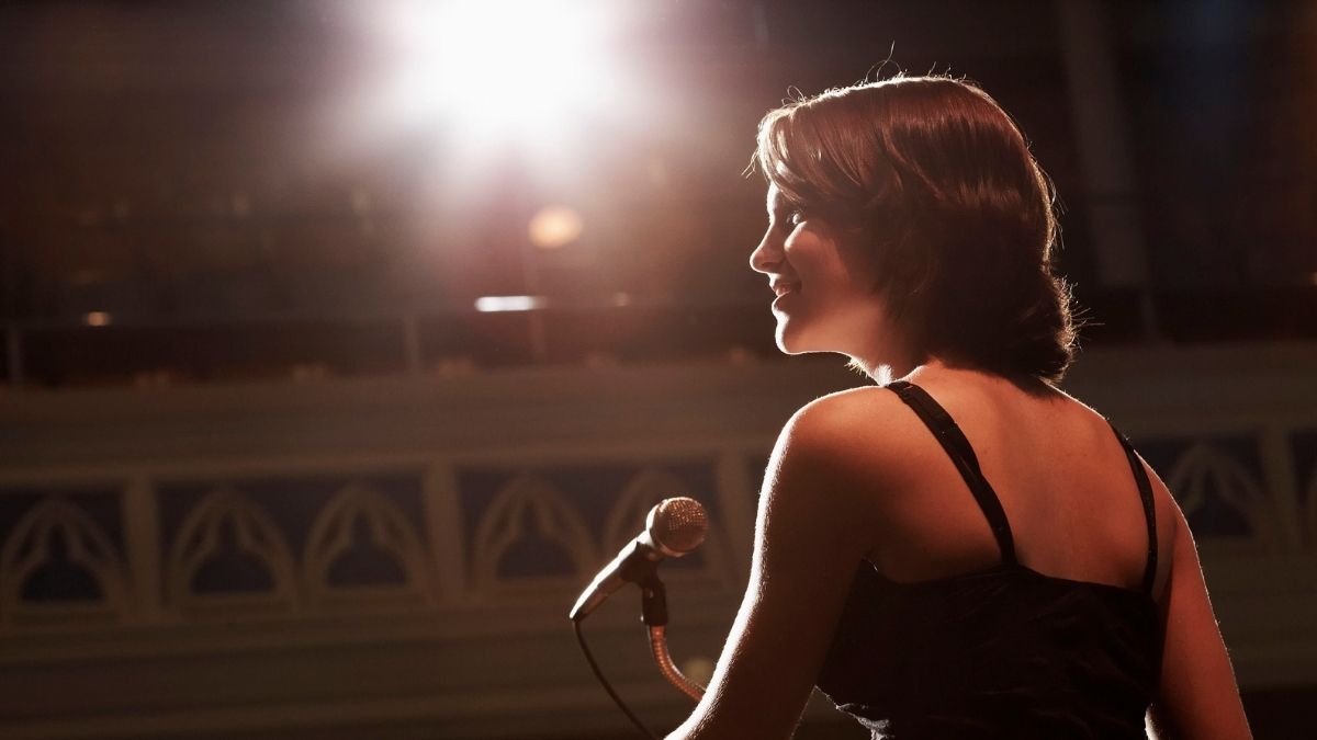 Woman speaking confidently at a lectern on stage, using storytelling in her speech